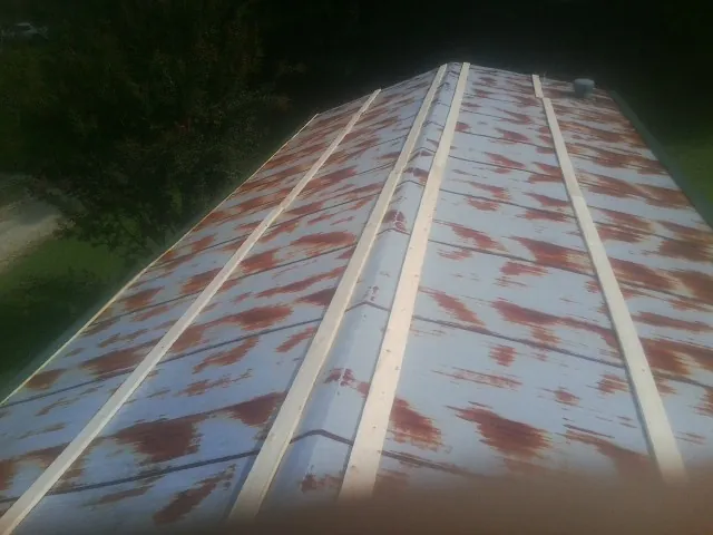 Rusted metal roof panels with new wood purlins before replacement — Storm Damage Roof Repair in Haslet by Roofing Brothers