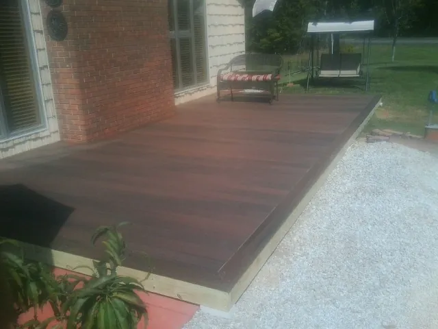 Freshly stained wood deck built against a brick home in Haslet