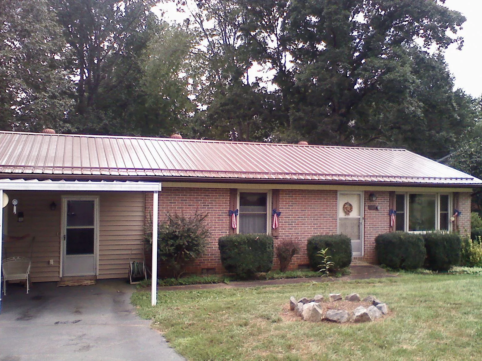 Bronze metal roof and carport on a brick ranch home — Roof Repair work by our crew in Haslet